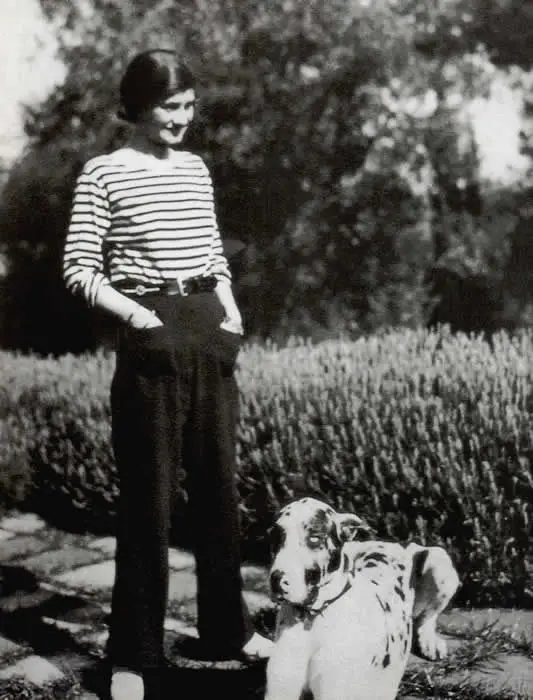 Coco Chanel portant une marinière et posant avec son chien, photographie mode et historique